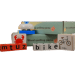 Wooden alphabet spelling game with bell on table